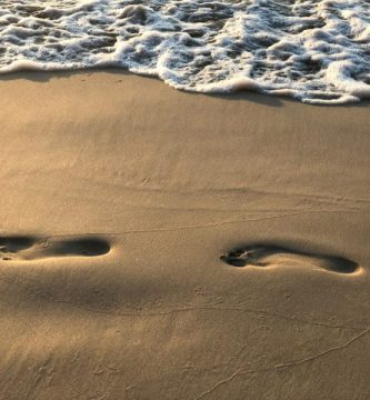 Huellas en la arena representando la de carbono